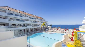Un hôtel doté d’une piscine, de plusieurs balcons et offrant une vue sur la mer.