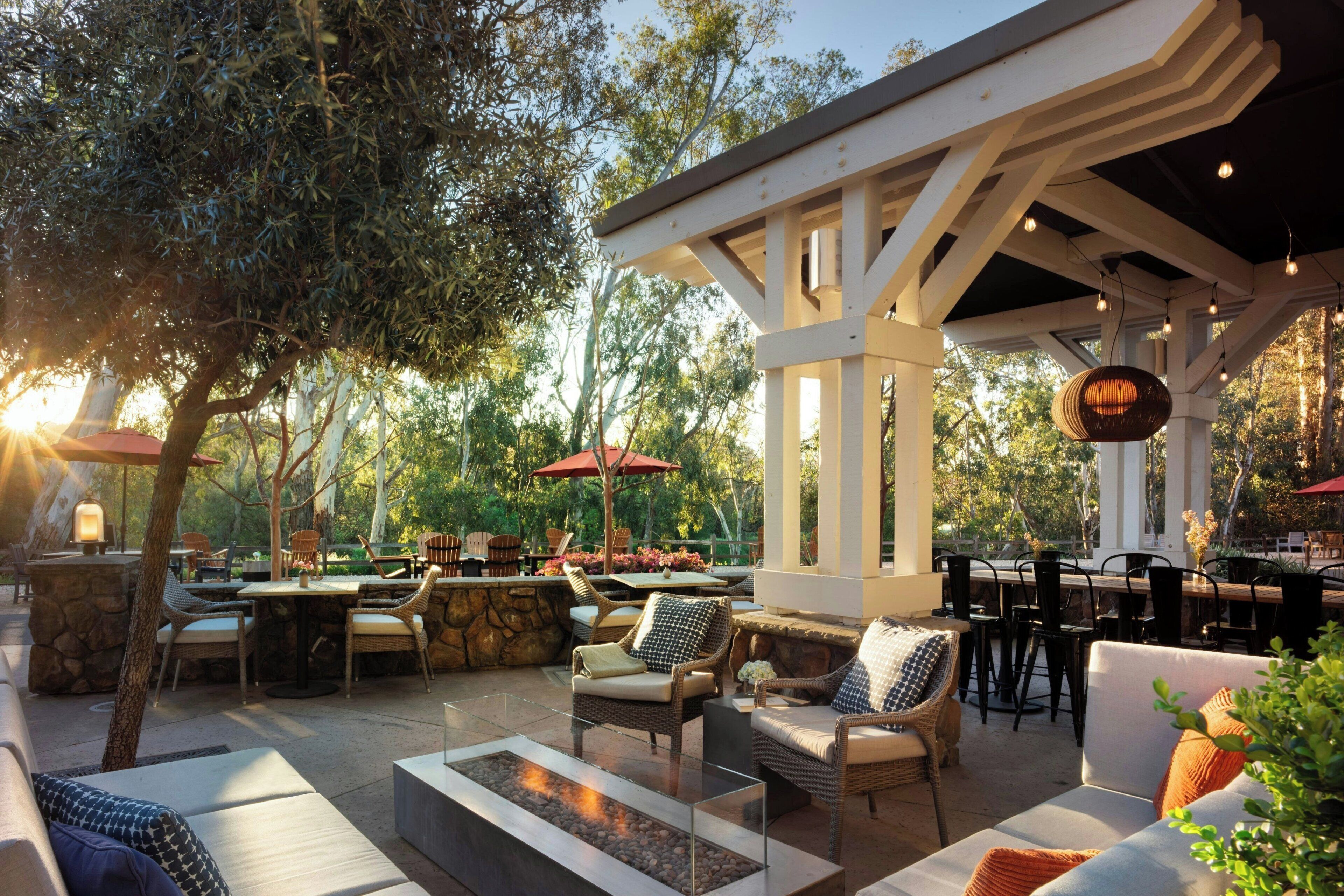 An outdoor patio with seating, a fire pit, and a pergola structure.