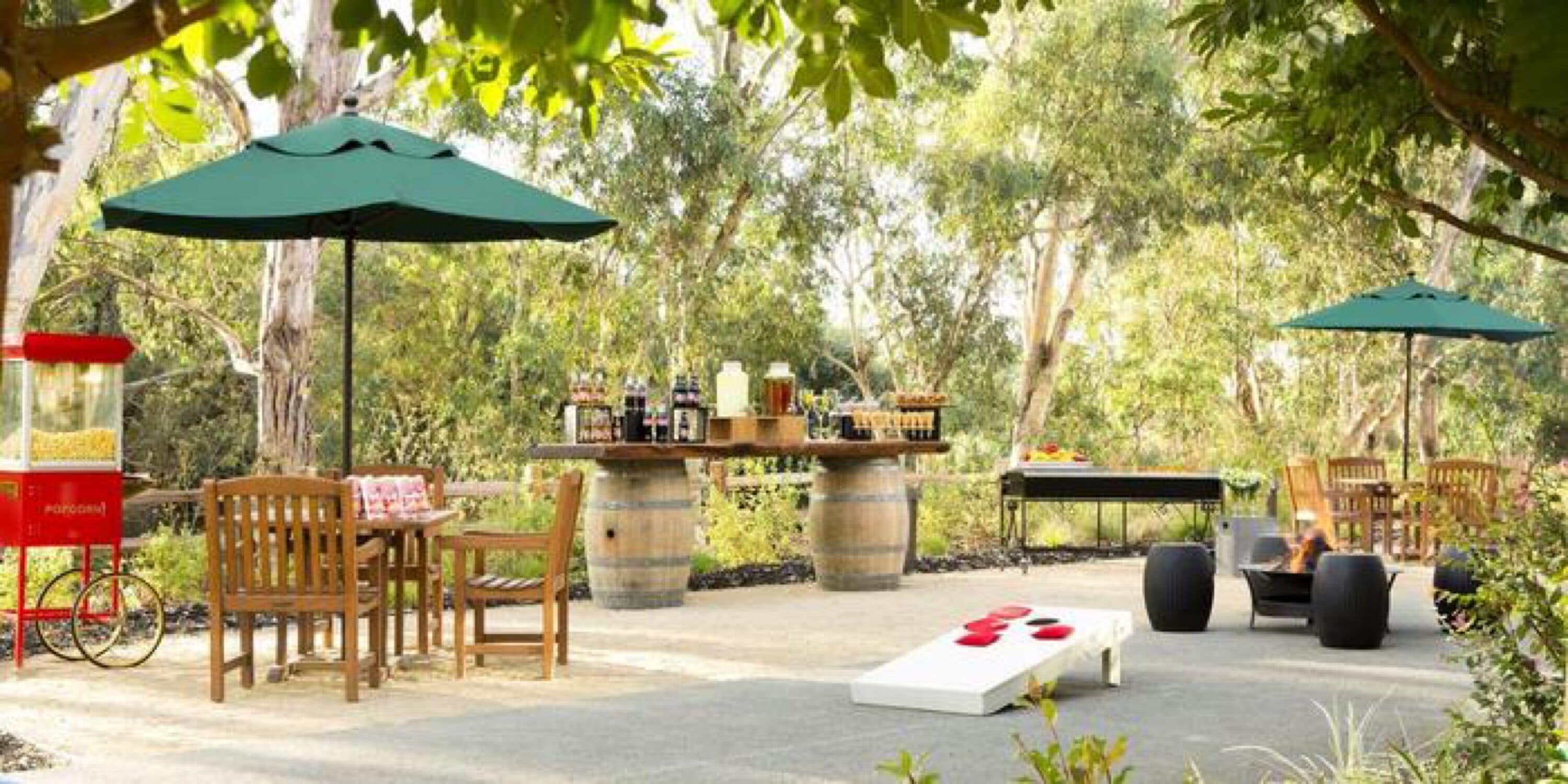 An outdoor patio area with wooden furniture, a dartboard, and a snack bar.