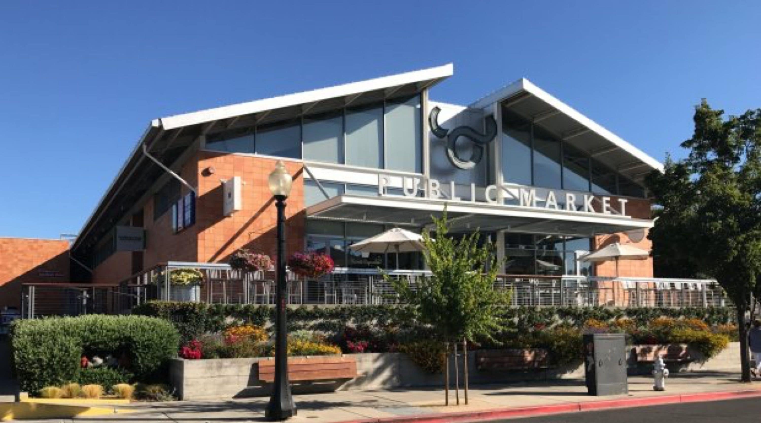 A public market building with a modern architectural design, featuring large glass windows and a prominent entrance.