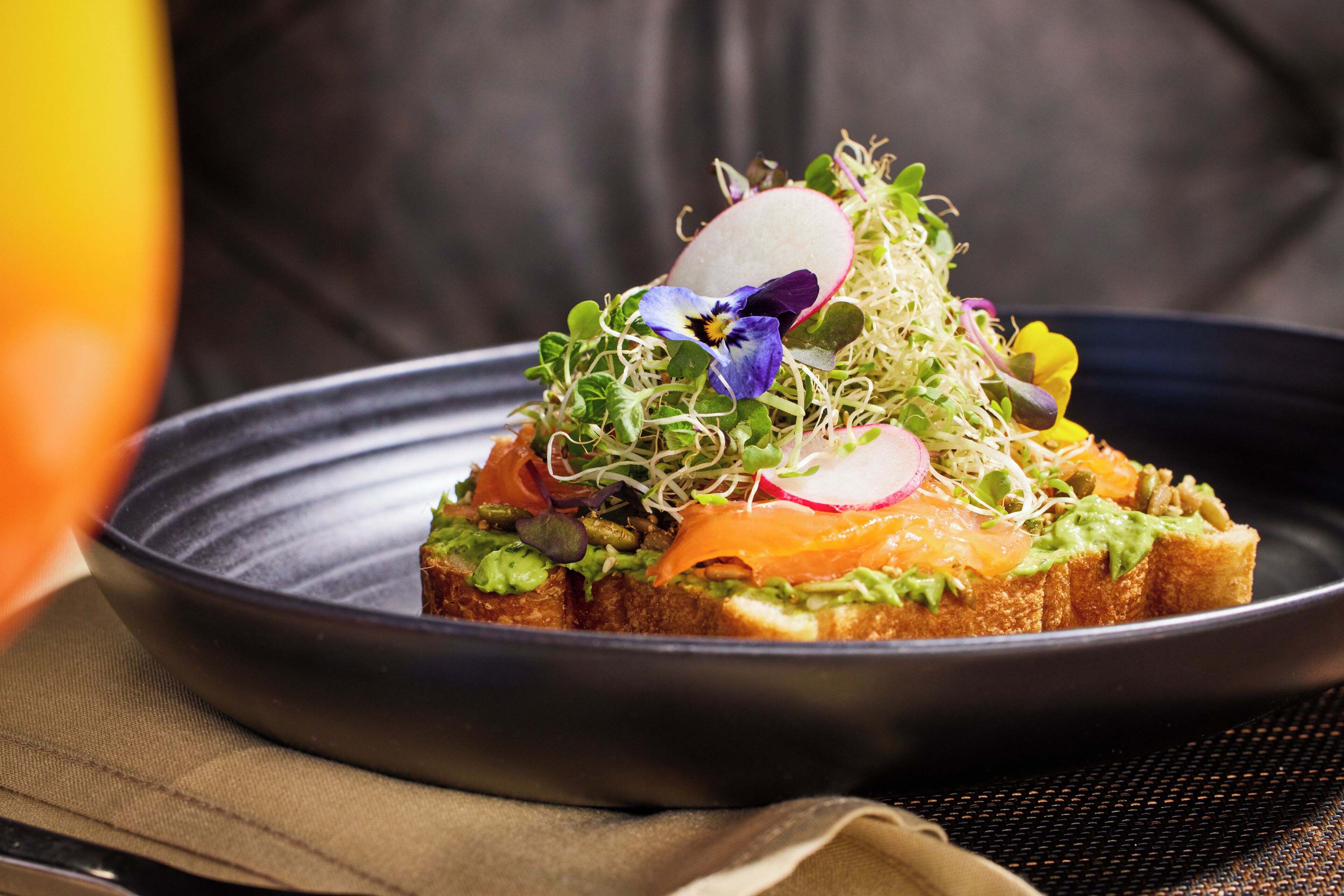 A dish with various toppings on a dark plate.