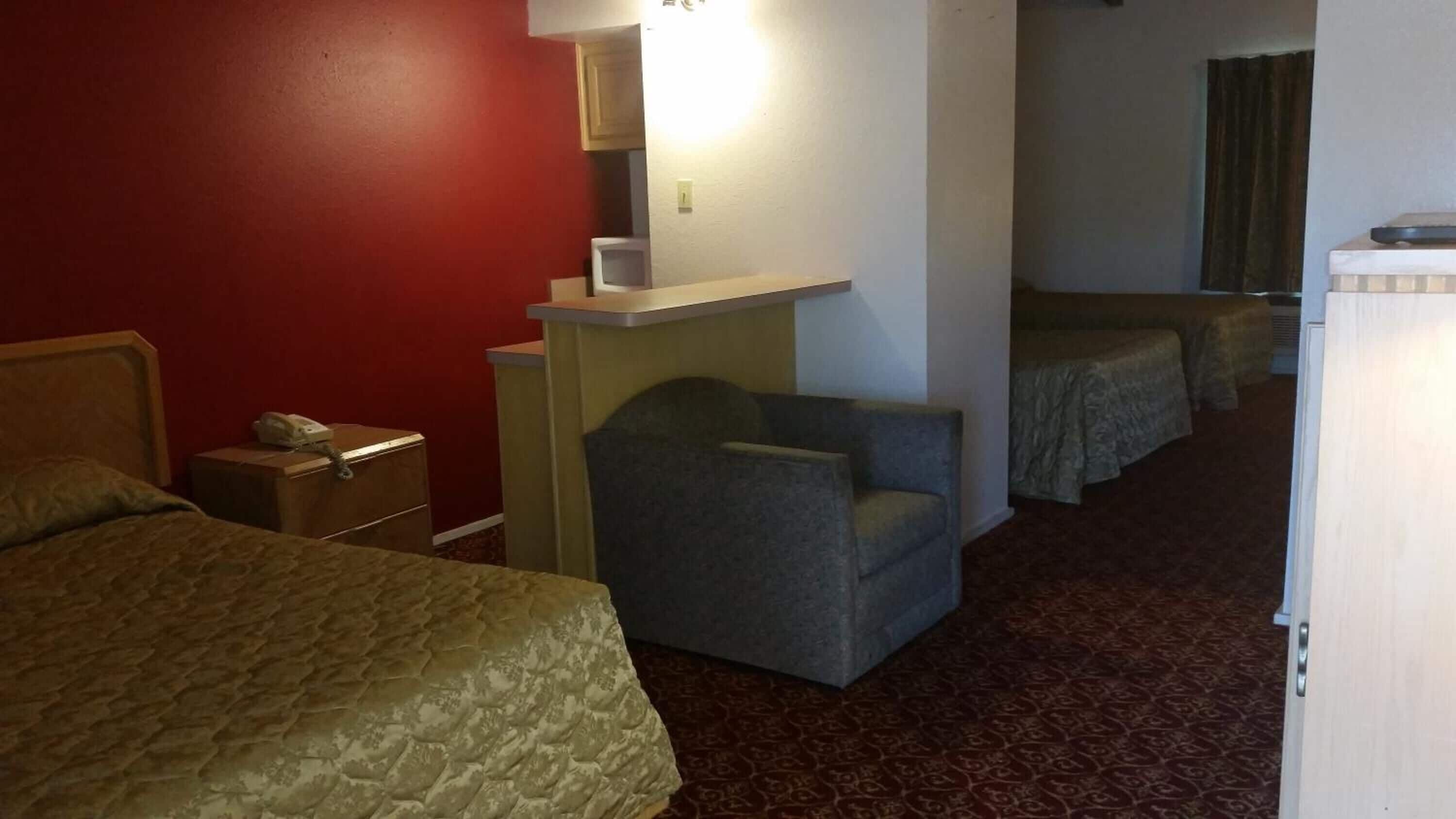 Une chambre d’hôtel comprenant un lit, un bureau avec un téléphone, une chaise et une petite table.