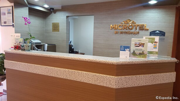 Una recepción de hotel con un letrero que dice "MICROTEL BY WYNDHAM".