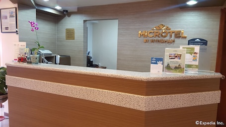 A reception desk at a hotel with a sign that reads "MICROTEL BY WYNDHAM".