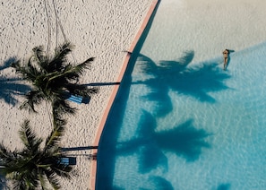 Una piscina al aire libre, sombrillas, tumbonas