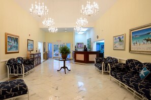A lobby with a reception desk, seating area, and artwork on the walls.