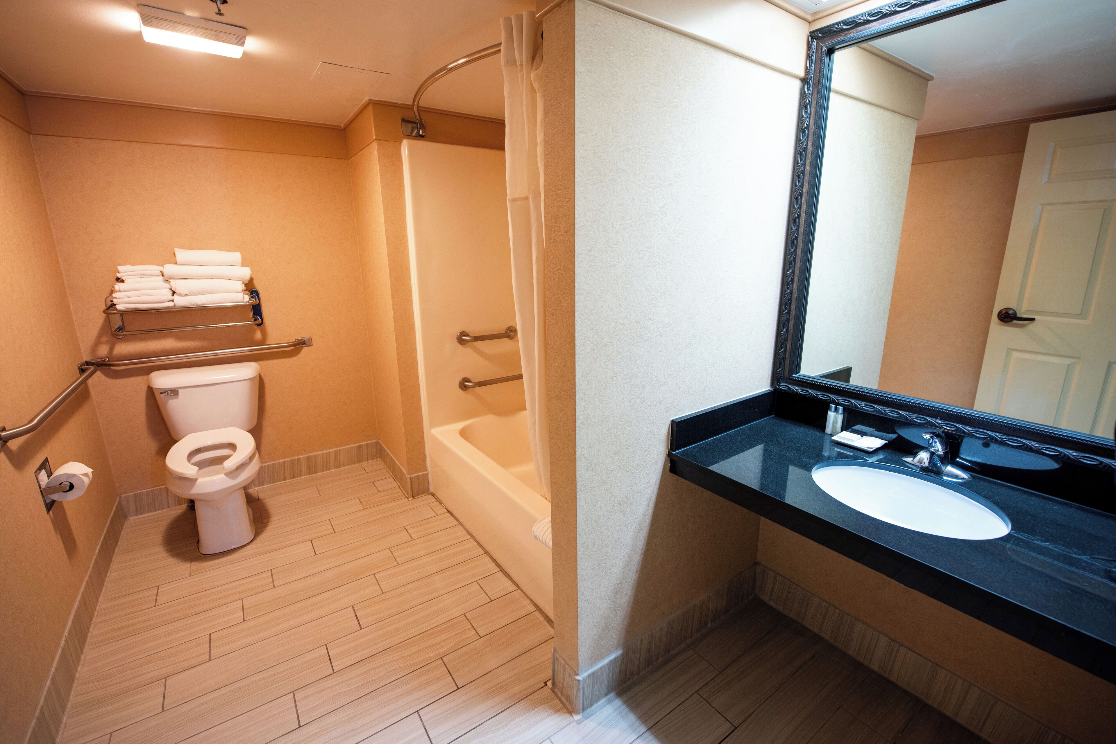 A bathroom with a toilet, bathtub, and sink with a mirror.