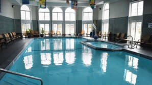 A large indoor swimming pool with multiple lanes, surrounded by lounge chairs and potted plants. - Hamilton Inn Select Beachfront Mackinaw City (Mackinaw City)