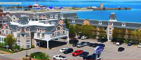 A hotel with a parking lot and a view of the water.