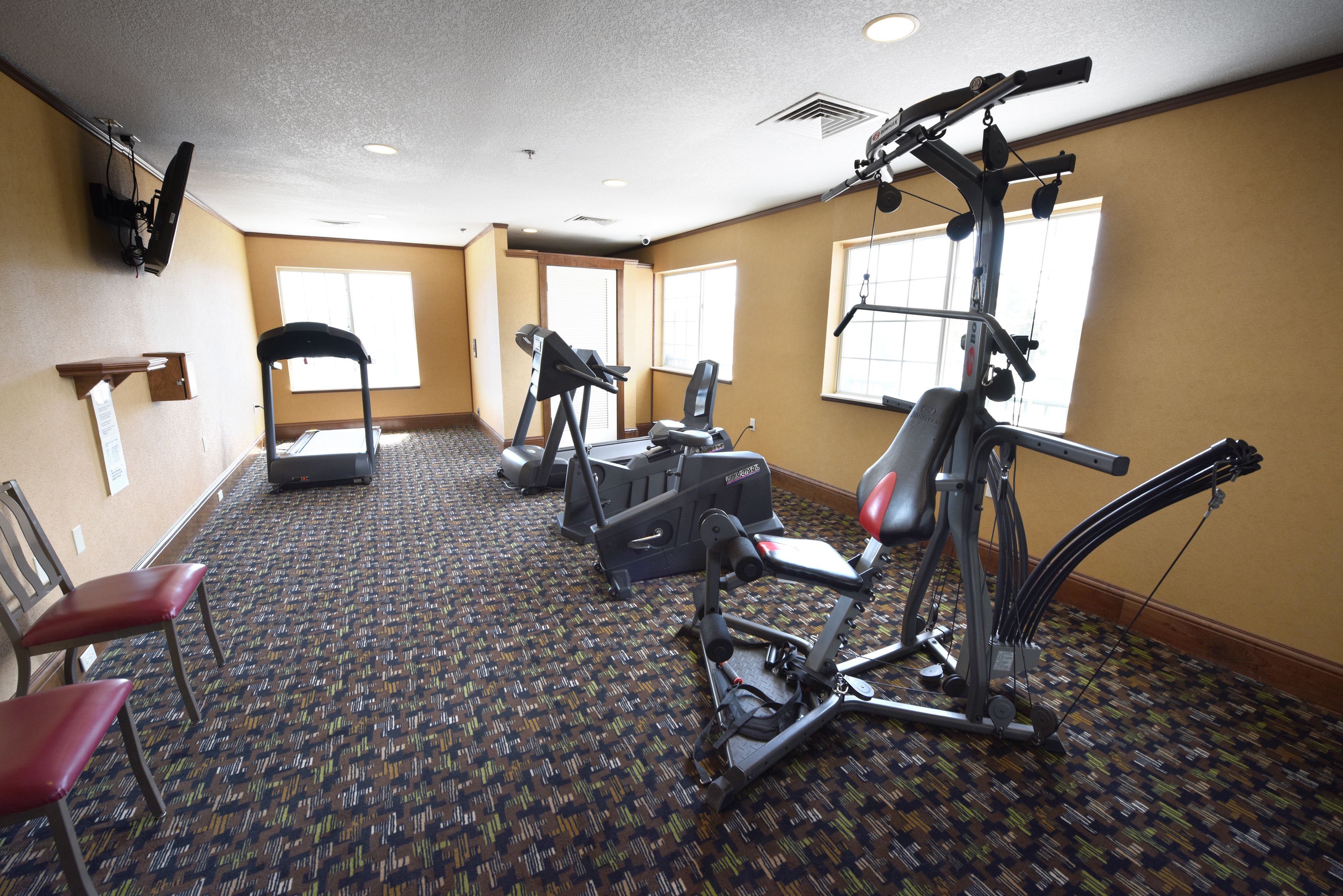 Une salle de sport équipée de tapis de course, de vélos d’appartement et d’appareils de musculation.