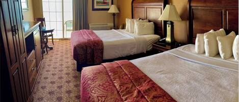 A hotel room with two beds, a desk, a chair, a lamp, and a painting on the wall.
