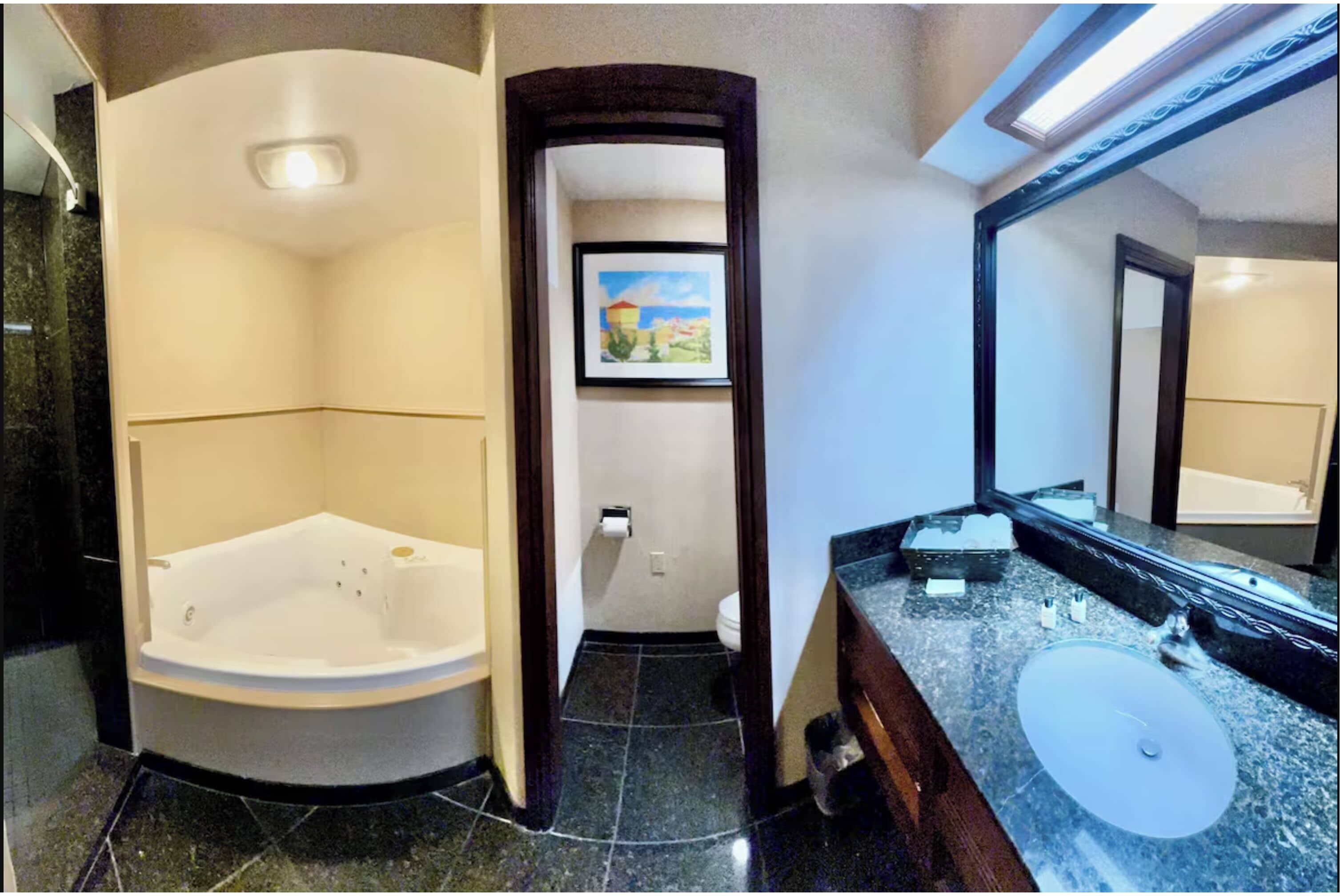 A bathroom with a large bathtub, a sink, and a mirror.