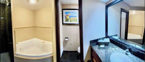 A bathroom with a large bathtub, a sink, and a mirror.