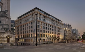 Un edificio grande e histórico con varios pisos, ventanas amplias y una entrada destacada.