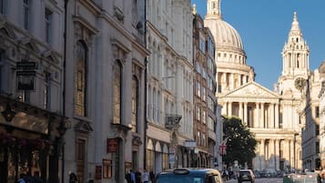 Une rue bordée de bâtiments historiques, dont un dôme imposant et des colonnes.