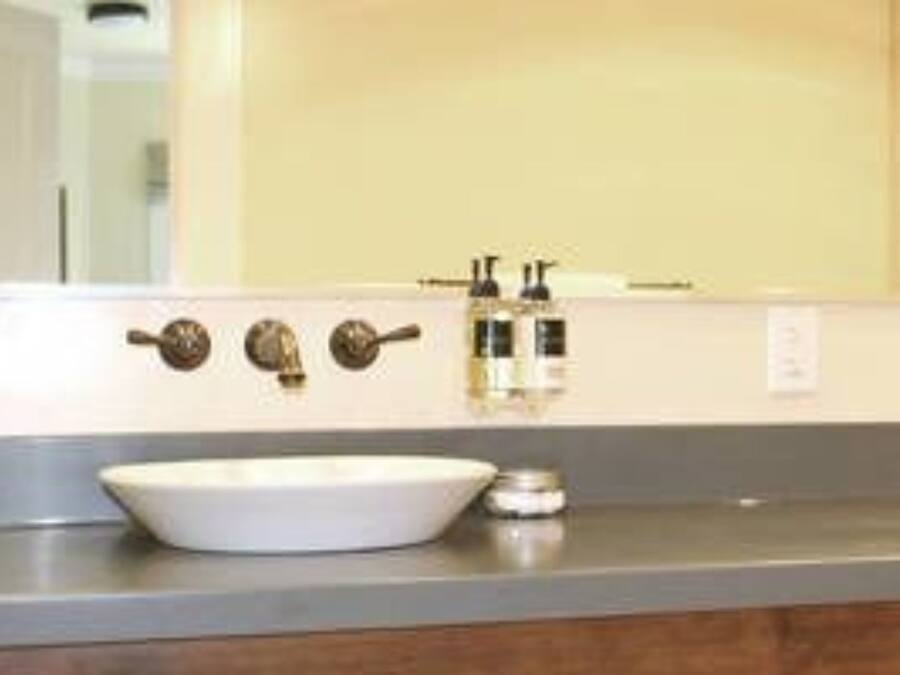 A bathroom with a white sink, two faucets, and a mirror above it.