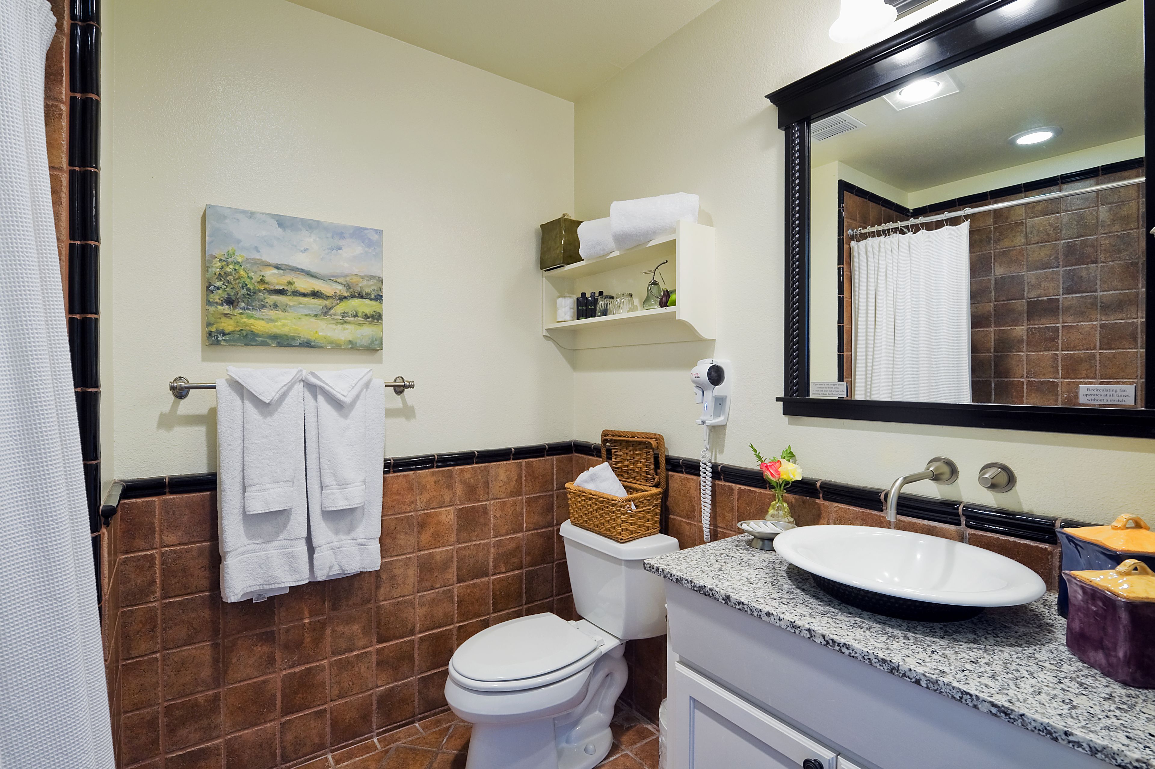 A bathroom with a white toilet, a sink with a mirror, and a towel rack.