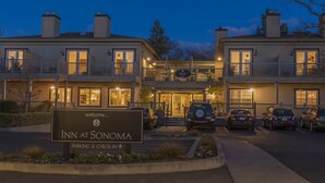 A hotel with a sign reading "Inn at Sonoma" and a parking area with several cars. - Inn At Sonoma - A Four Sisters Inn (Sonoma)