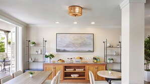A modern kitchen with wooden cabinets, a central island, and a large window. - Inn At Sonoma - A Four Sisters Inn (Sonoma)