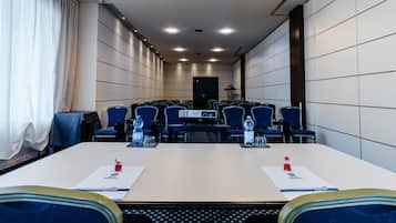 A conference room with a long table, blue chairs, and a projector.