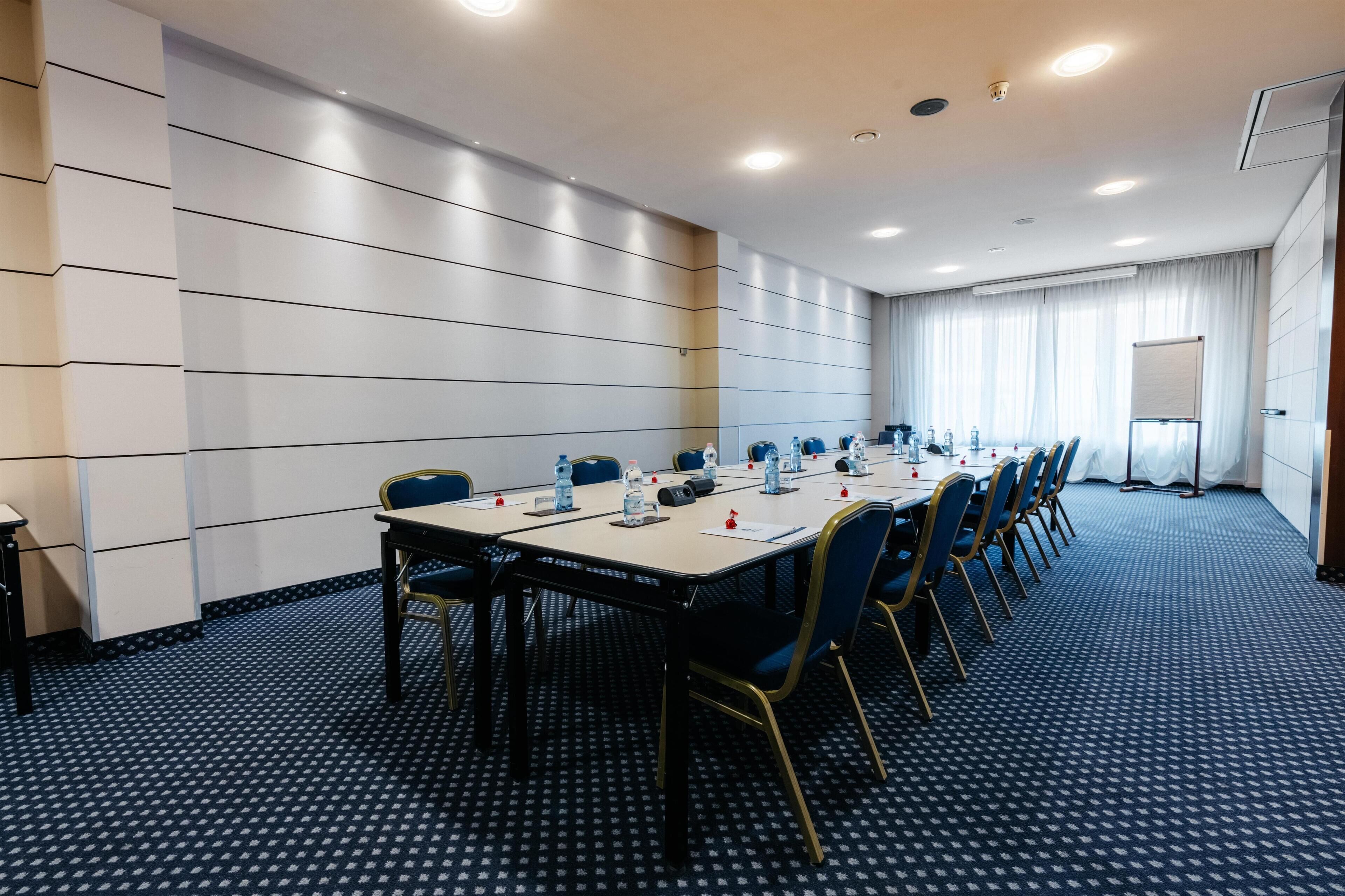 A conference room with a long table, chairs, and a whiteboard.