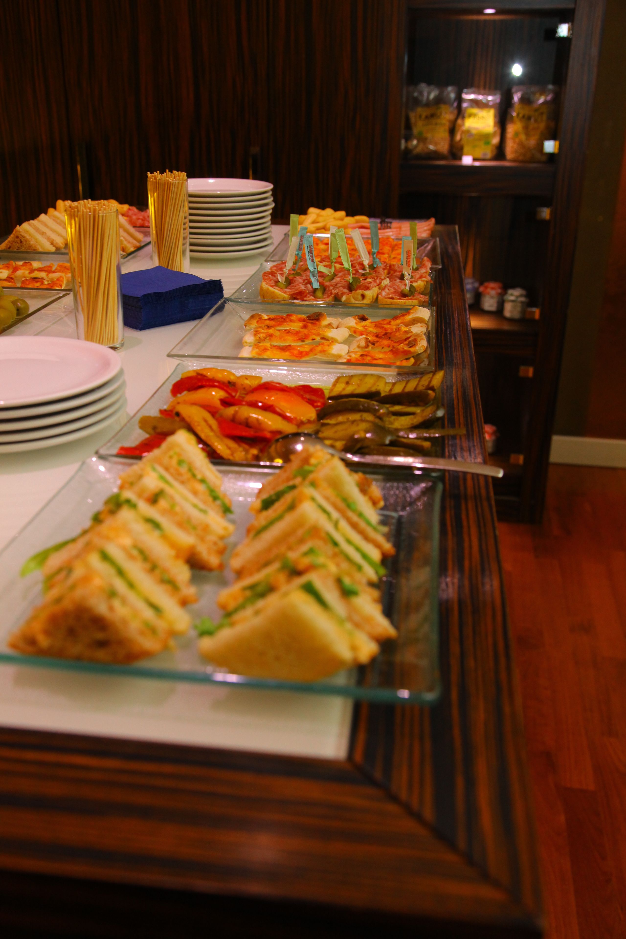 A buffet with various food items including sandwiches, pasta, and salads.