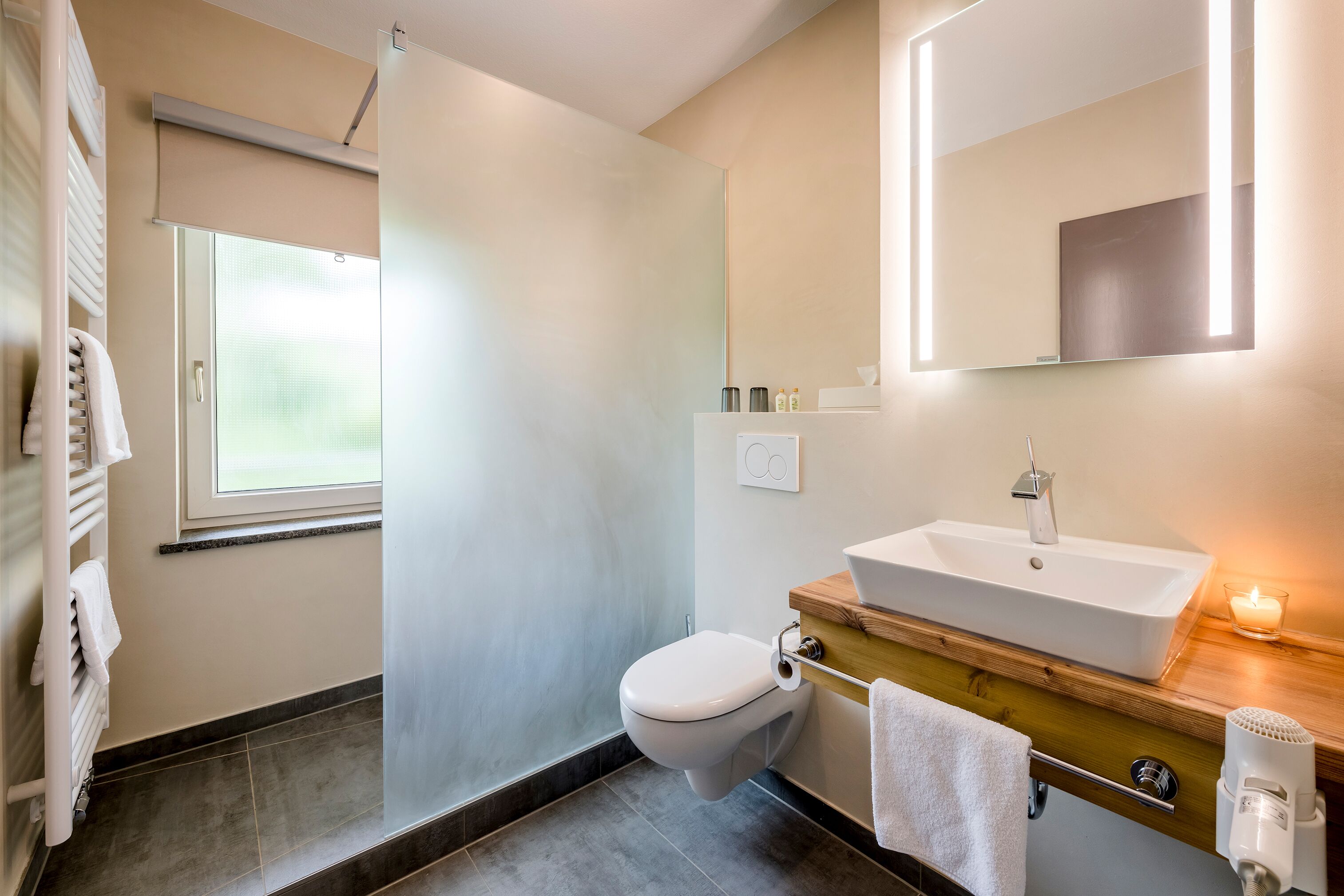 Ein modernes Badezimmer mit Toilette, Waschbecken und Dusche.