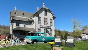 A large, historic building labeled "Chambéry Inn" with a vintage turquoise truck parked in front. - Chambery Inn (Lee)