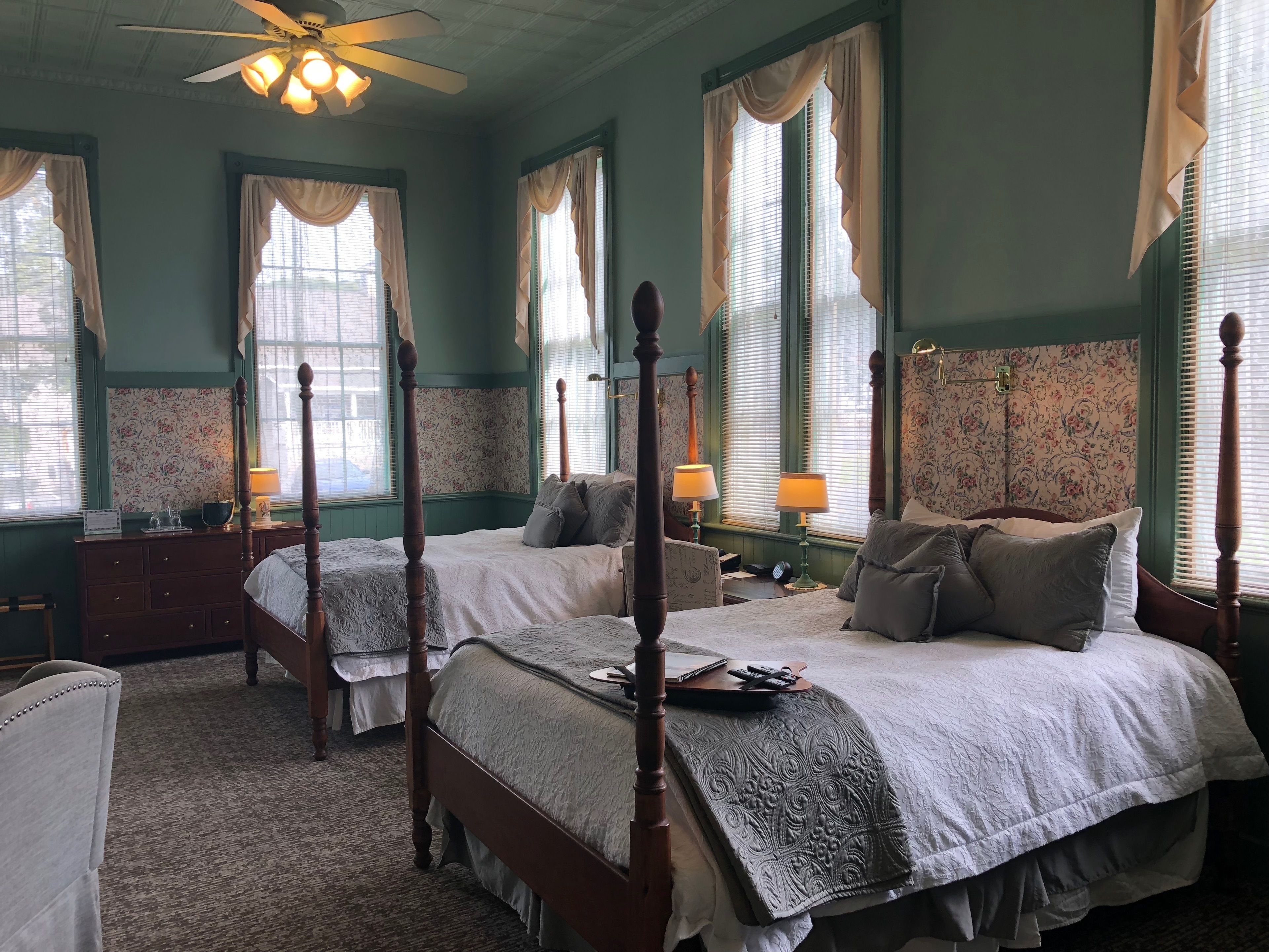A four-poster bed with a wooden frame, two bedside tables, and a nightstand.