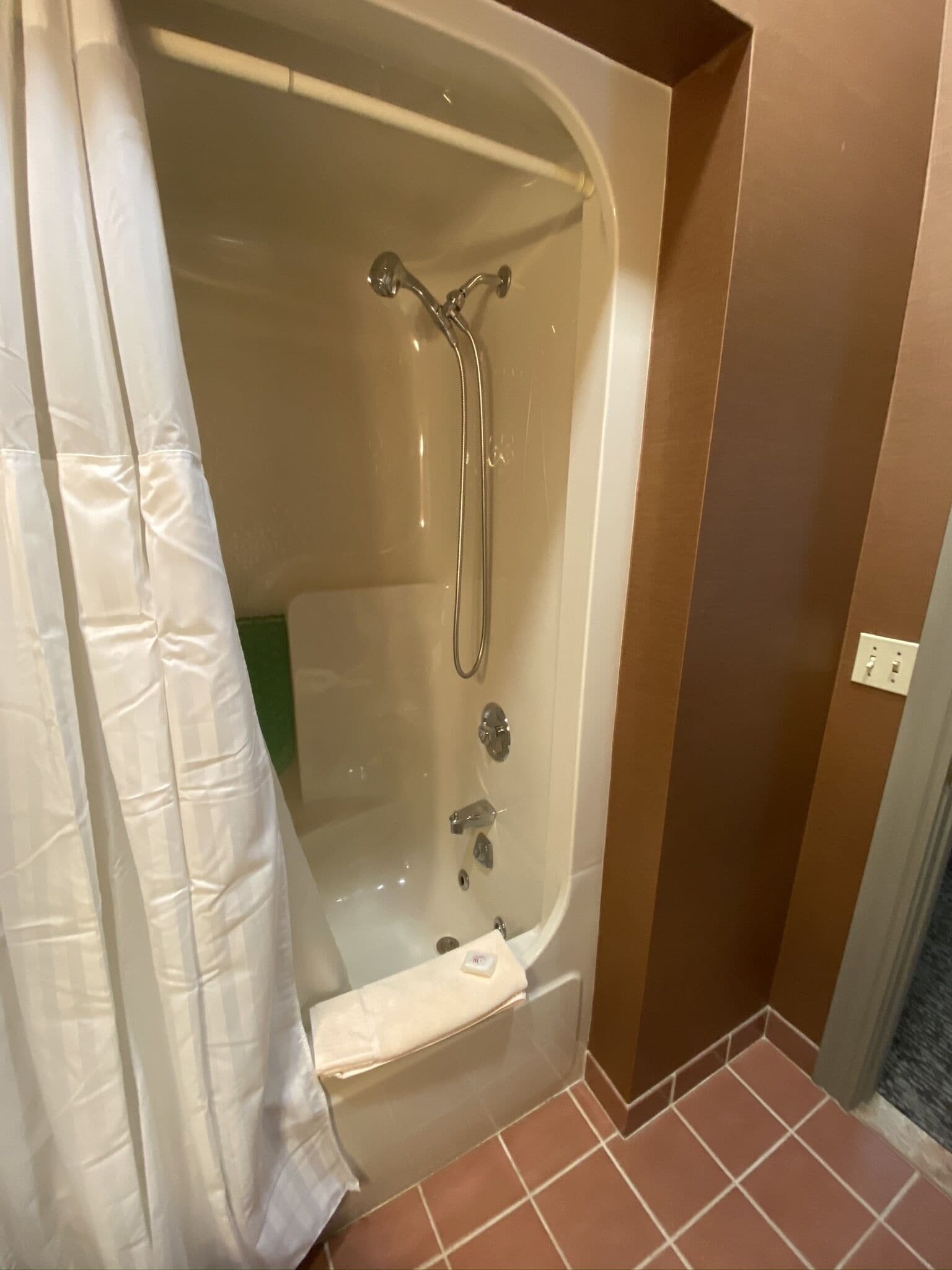Ein Badezimmer mit Badewanne, Dusche und Handtuchhalter.