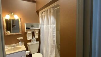 A bathroom with a sink, toilet, and shower curtain.