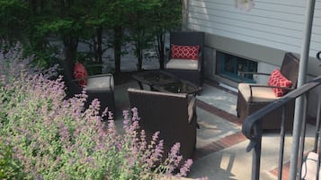 A patio with outdoor furniture, a staircase, and a garden with various plants.