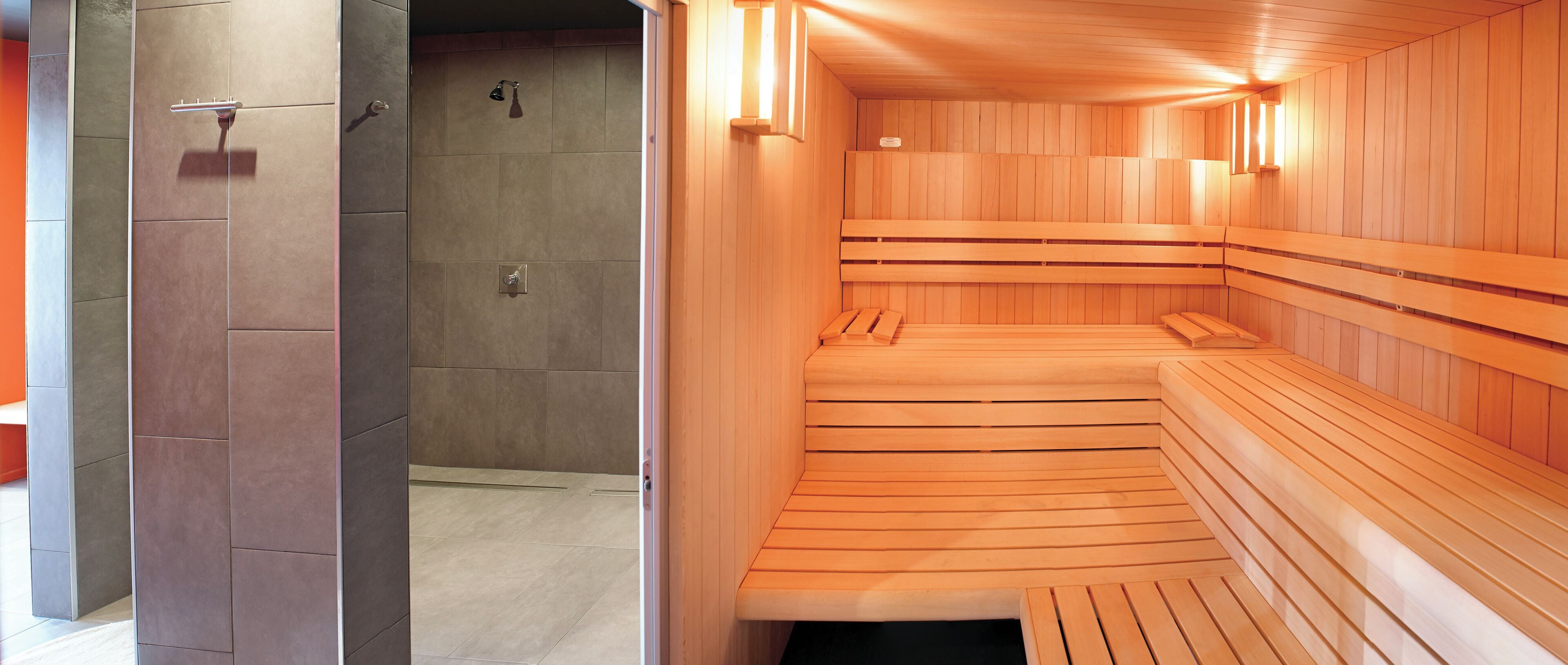 A sauna with wooden benches and wall-mounted lights.