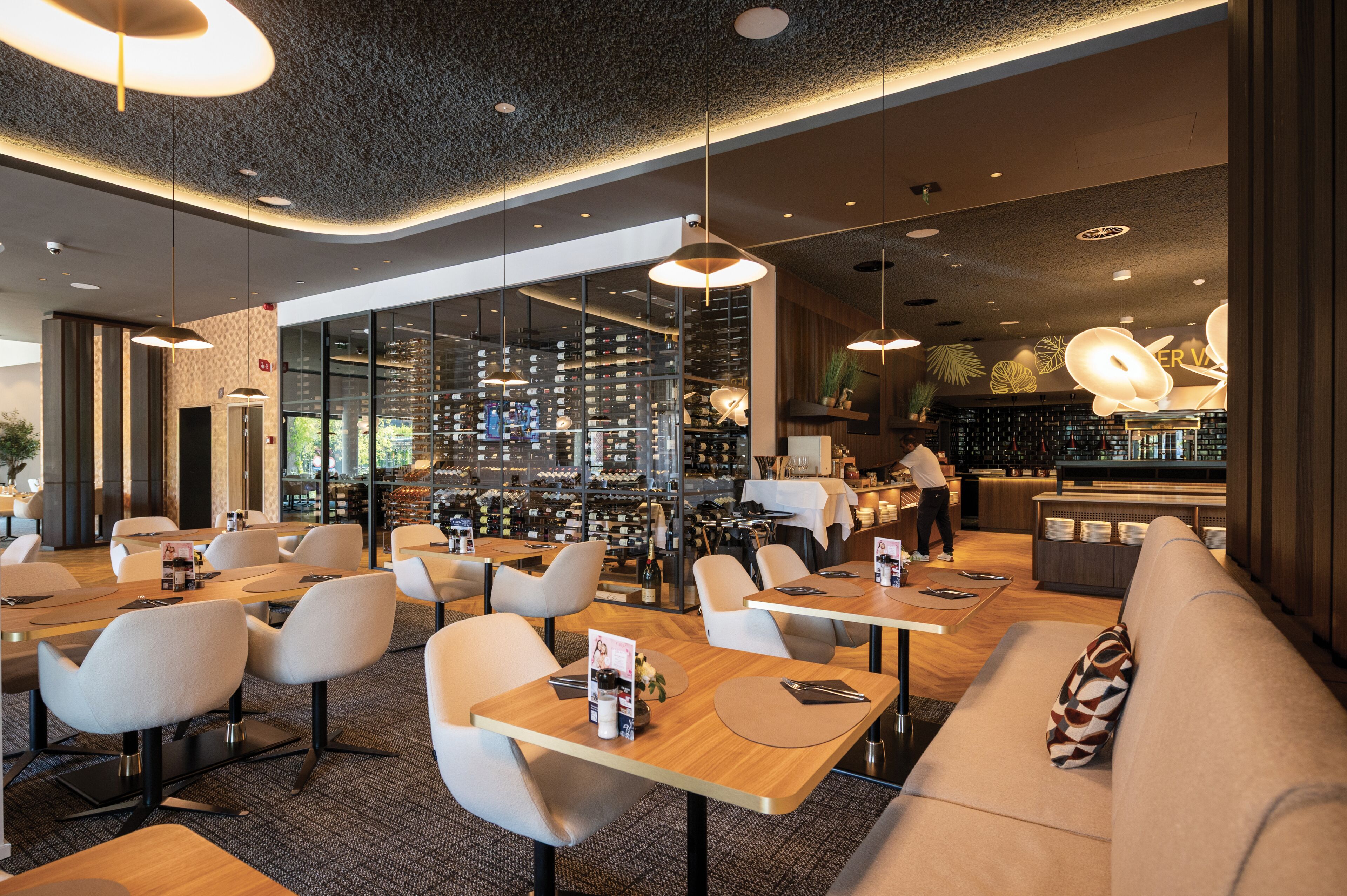 Un restaurante moderno con una bodega de vinos, zonas de estar y un bar.