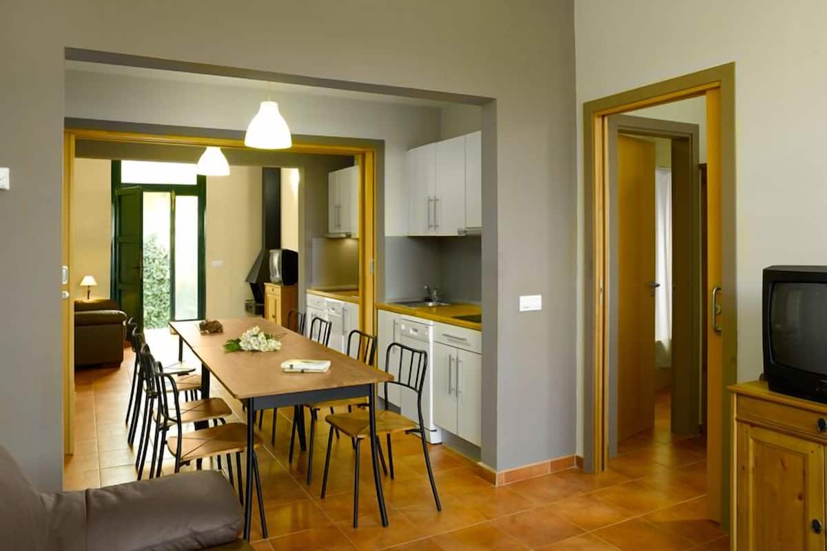 Een compacte woonruimte met een eethoek, kitchenette en televisie.