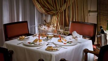 A dining table set with plates, cutlery, and glasses, surrounded by chairs.