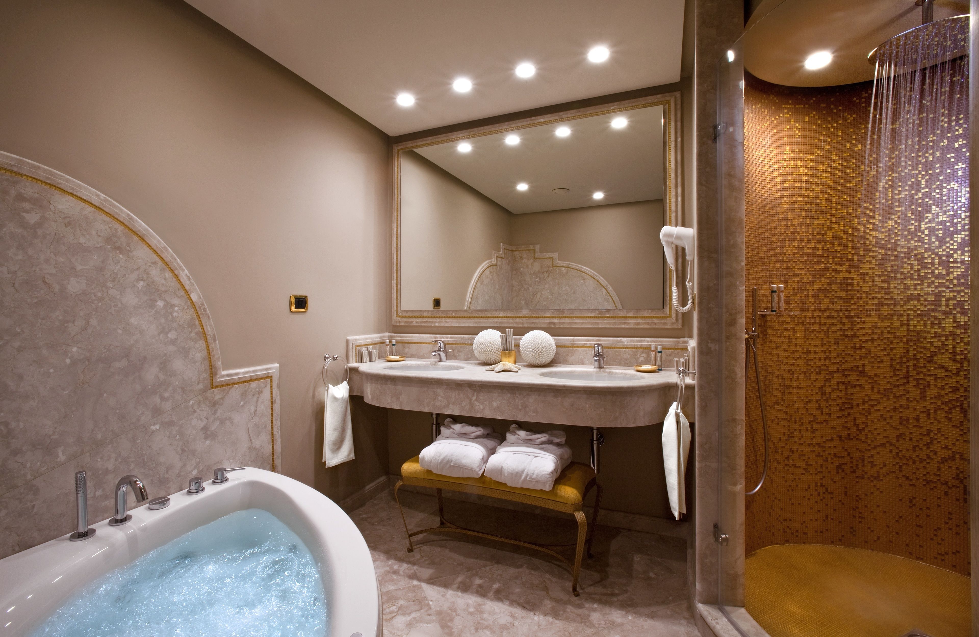 A bathroom with a marble vanity, a bathtub, and a shower area.
