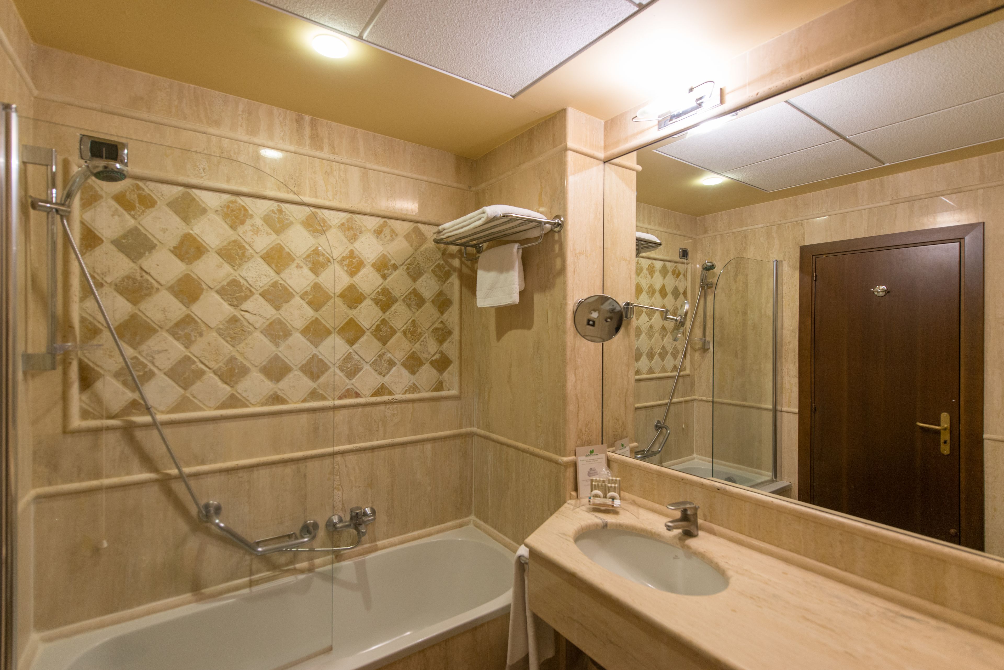 A bathroom with a bathtub, a sink, a shower, and a mirror.