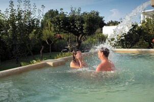 Una piscina al aire libre de temporada, sombrillas