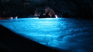 An underwater cave with a boat and a person visible in the distance. - Hotel Al Mulino - Mediterranean Garden Retreat in AnaCapri (Anacapri)