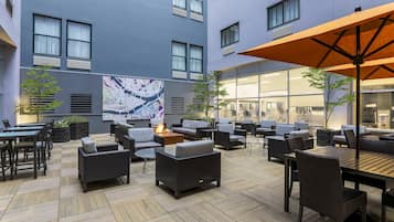 An outdoor patio area with modern furniture, a map mural, and a fire feature.