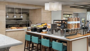 Una cocina moderna con un espacio tipo buffet, que incluye diversas opciones de comida y una estación de café.