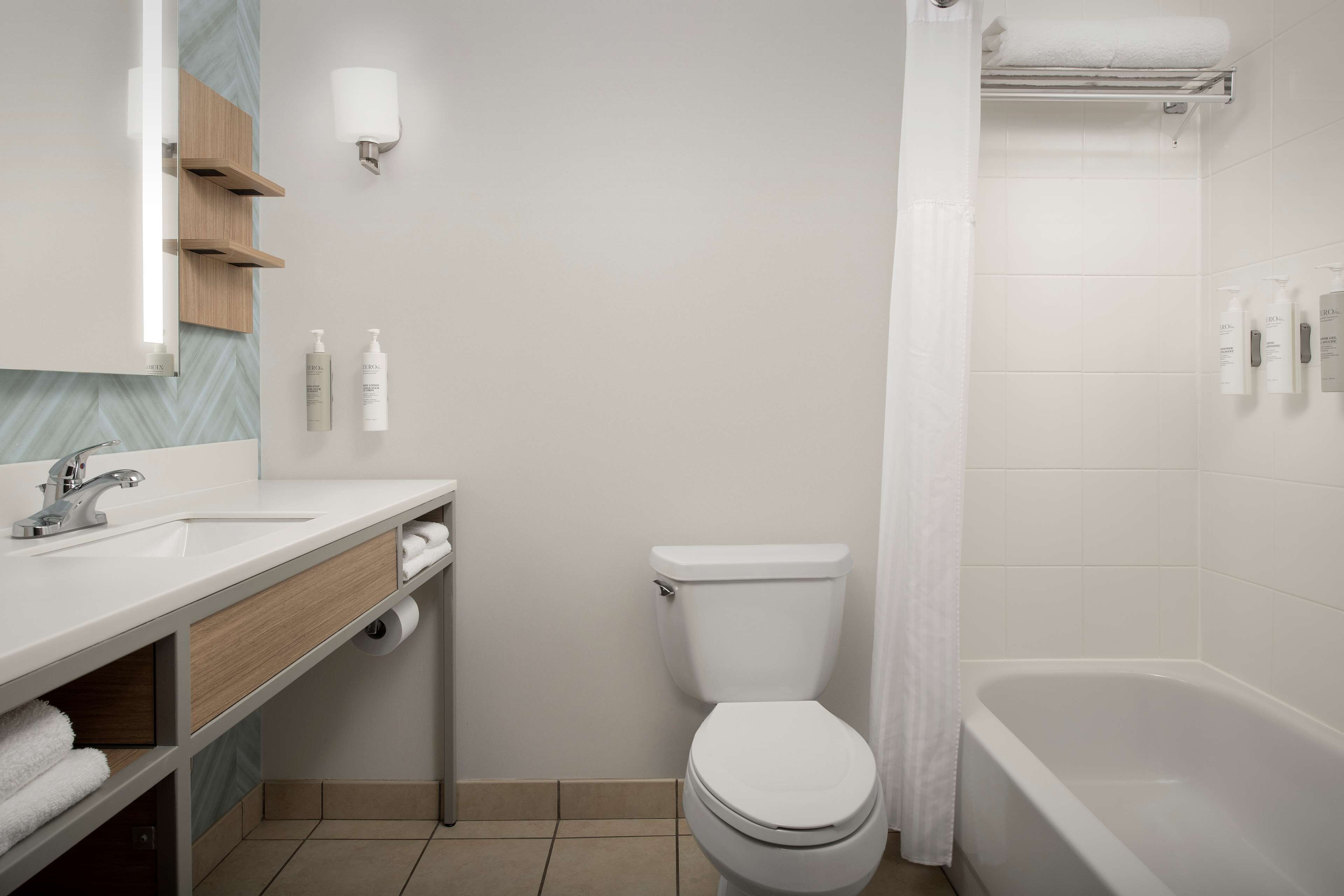 combined shower/bathtub, designer toiletries, hair dryer, towels