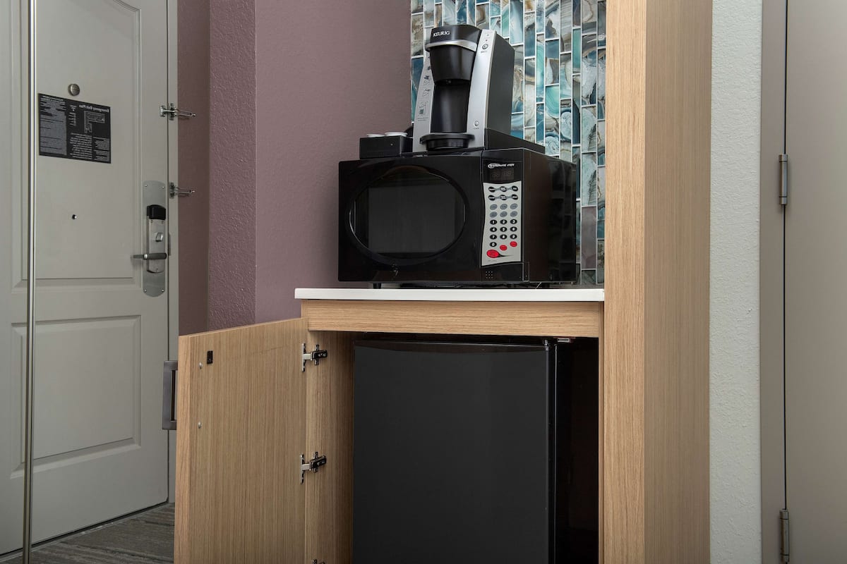 Une petite cuisine équipée d’une machine à café, d’un four à micro-ondes et d’un réfrigérateur.