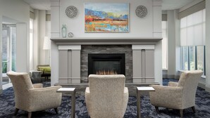 Una sala de estar moderna con chimenea, dos sillones y una mesa de centro.