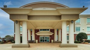A hotel entrance with a covered walkway, large columns, and a brick facade.