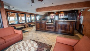 Eine geräumige Lobby mit Rezeption, Sitzgelegenheiten und großen Fenstern mit Blick ins Freie.