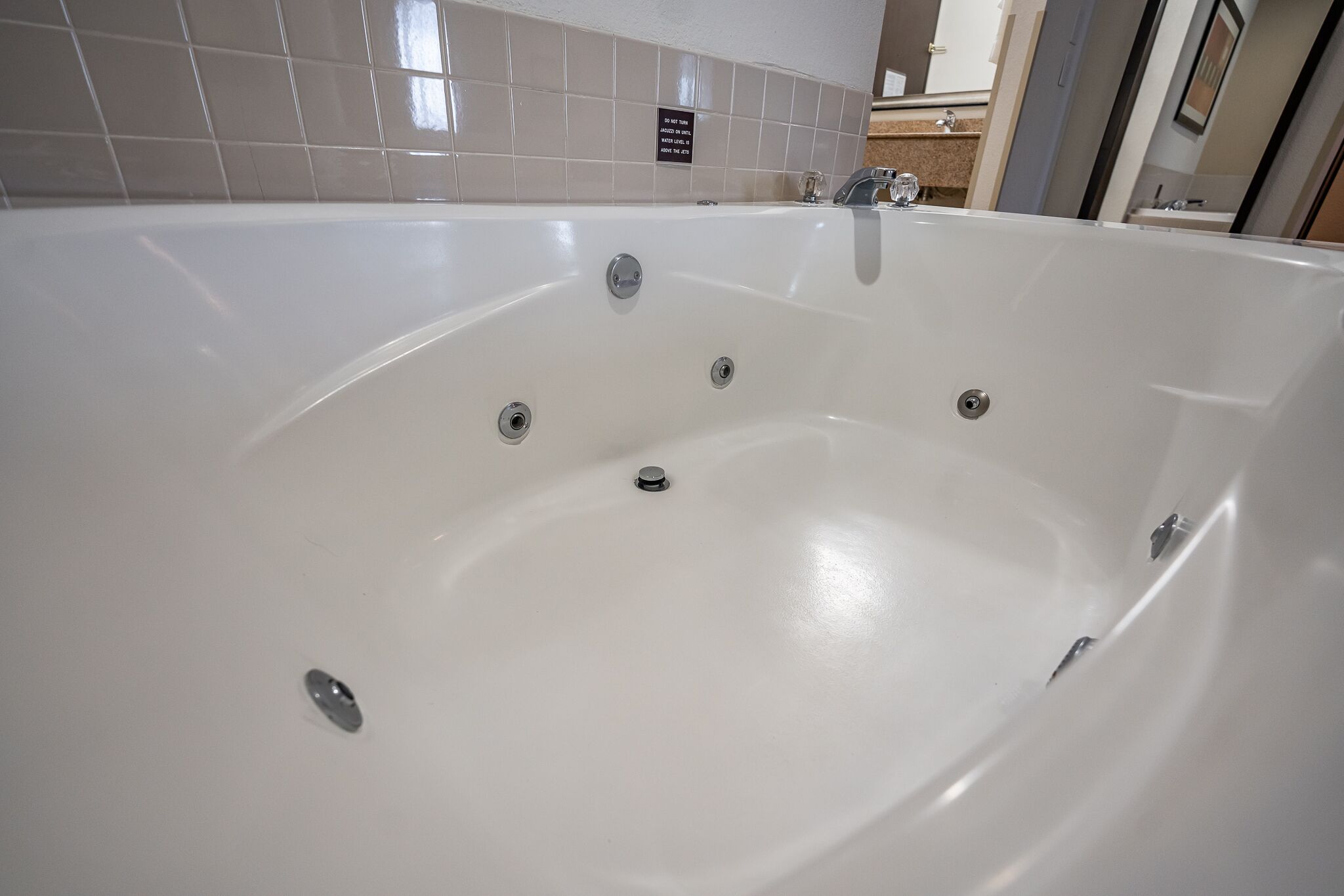 Una bañera grande y blanca con múltiples grifos y desagüe.