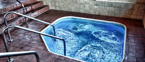 A swimming pool with a metal ladder and steps leading up to it.