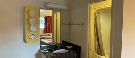 A bathroom with a sink, mirror, and toilet.